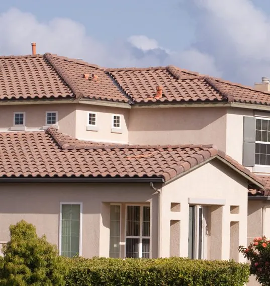 Two-story stucco home with a terracotta tile roof